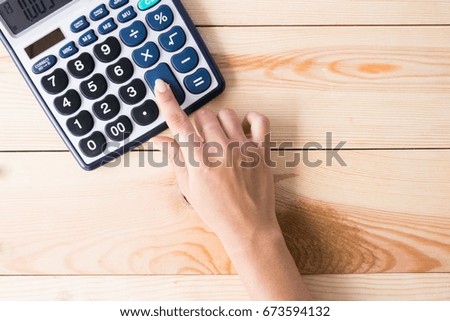 woman use calculator  on wooden background in concept business, finance, education 