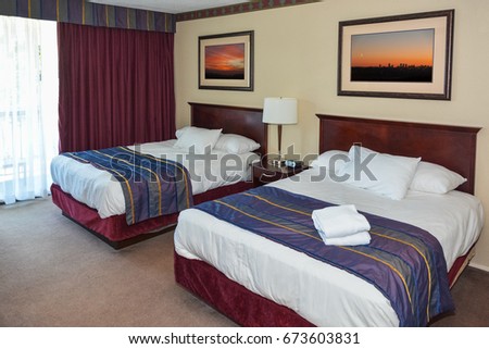 Two made up beds in a hotel room