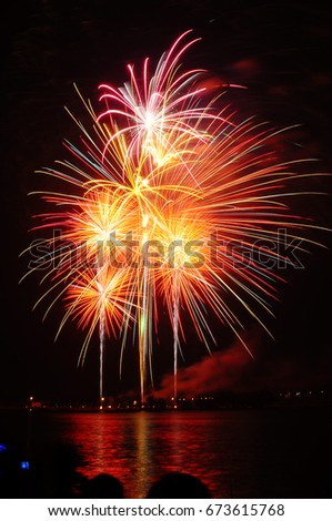 Fireworks light up the sky over river. Copy space.