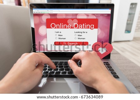 Person Using Online Dating Website On Laptop