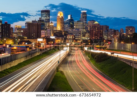Heavy traffic flowing in and out of Minneapolis during a beautiful sunset Shot with a long exposure creating light trails from the moving traffic.