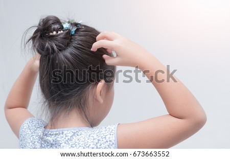 little girl hand itchy scalp on gray background, Hair care concept