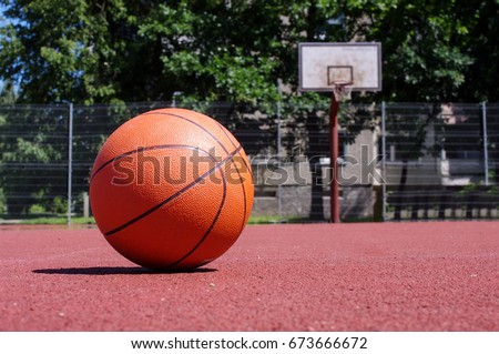 Basketball ball in the outdoors court sunny day Royalty-Free Stock Photo #673666672
