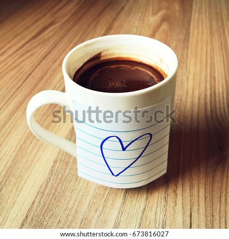 White mug with dark coffee. Mug with sticky notes with heart. Coffee mug with heart. Love coffee. Morning coffee