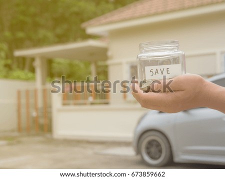 Hand putting golden coins in money jar. Concept of investment property, home insurance, savings plan for housing and car.