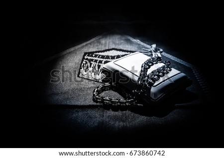 Holy Quran with beads on a prayer mat, Muslim Tasbih is a string of prayer beads which is traditionally used by Muslims along with the Quran. Ramadan holidays concept. Selective focus Royalty-Free Stock Photo #673860742