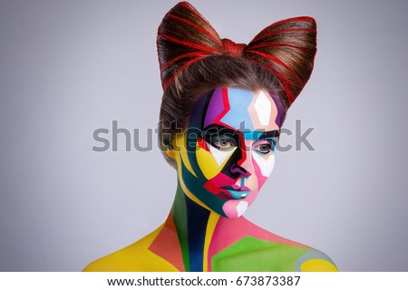 Model looks like character from comics pages. Woman with a creative pop art makeup on her face.