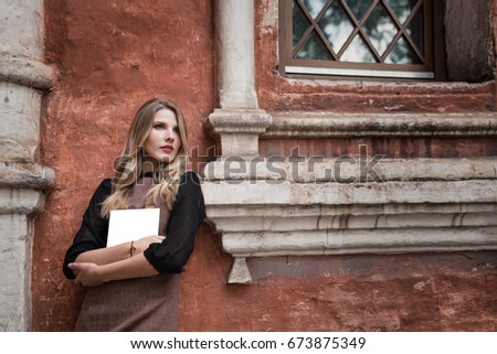Portrait of a beautiful woman holding a blank sheet for writing.
