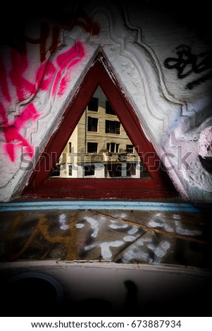 View of an old building through a triangle shaped window.  Black vignetting.