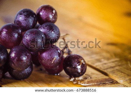 Fresh ripe red grapes on a wooden floor.