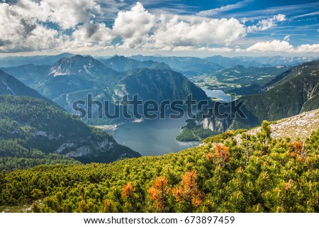 majestic view of lake surrounding Alp mountains against beautiful magic blue cloudy sky background from viewing platform Five Fingers in Obertraun, Austria
