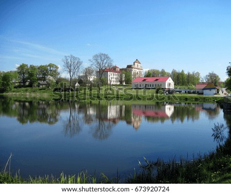 Reflection in water, building with red roof, abandoned church