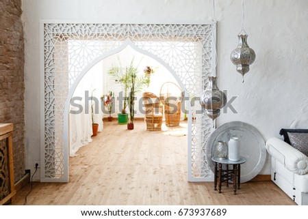 Eastern traditional interior. Arch with beautiful carving. White and gray room  Royalty-Free Stock Photo #673937689