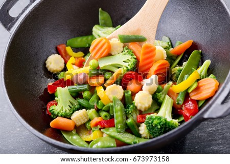 stir fried vegetables in a wok on dark table Royalty-Free Stock Photo #673973158