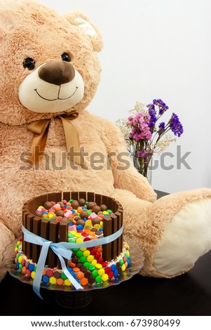 Happy birthday cake and big teddy bear. Festive tea party. Pinata Cake, a celebration cake with a hidden stash of sweets inside.