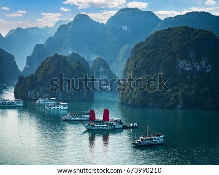 Viewpoint over Halong Bay with cruise ships in the ocean, Southeast Asia. UNESCO World Heritage Site. Beautiful scenery with sea and mountains, most popular landmark, tourist destination of Vietnam. Royalty-Free Stock Photo #673990210