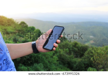 Left hand use phone on mountain view.hand of technology
