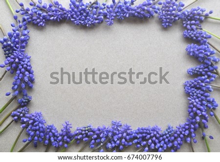 Top view of a brown kraft paper background with purple violet lavender spring bulb flowers for copy and text