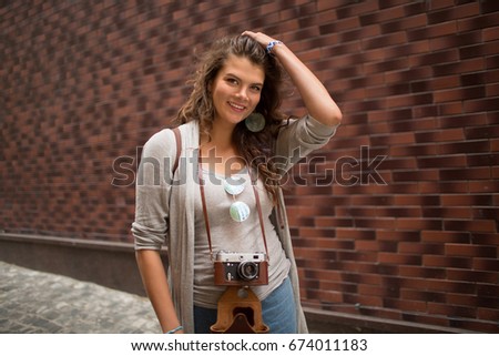 Happy tourist woman smiling in camera. Girl posing for camera touching hair.