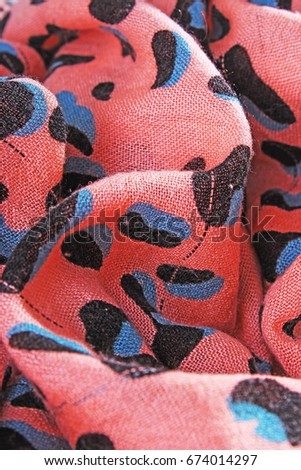 Peach colored animal printed fabric cloth scarf as background.