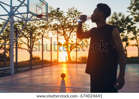 young black handsome man drinking water basketball on sunrise, morning sports, healthy lifestyle, having fun