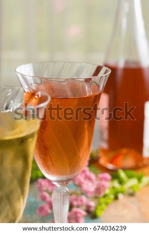 Cold summer wines, white and rose, served in beautiful glasses on terrace in cafe with romantic flowers, close up