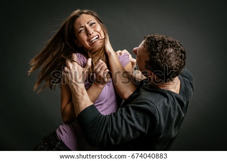 Angry aggressive husband trying to hit his wife.