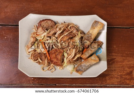 Filipino Chinese Fusion Food called a Lauriat which usually consists of pancit canton or rice noodles and lumpiang shanghai or spring rolls. Flat Lay shot. 