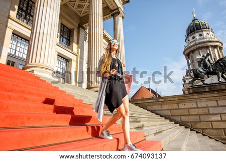 Young woman tourist walking on the stairs near the Concert house in Berlin