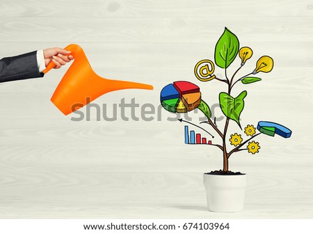 Hand of businesswoman watering concept of business plan and strategy