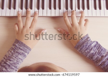 Beautiful girls hands playing electronic piano keyboards