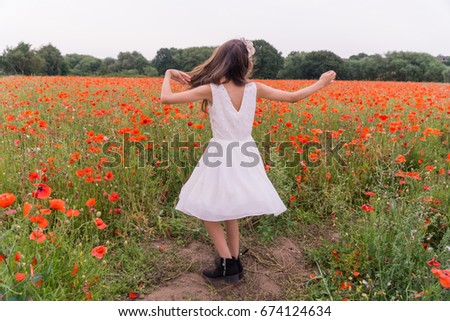 poppy fields in the summertime with a girl spinning around
