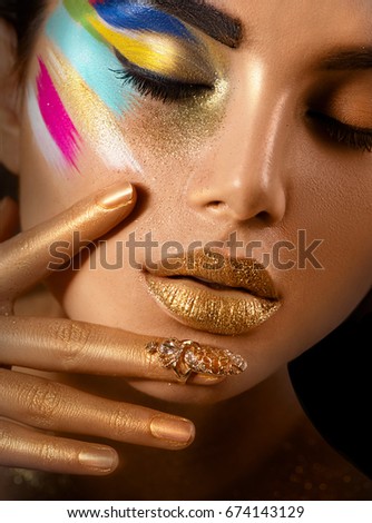 Fashion Model Girl with colored face painted. Beauty fashion art portrait of beautiful woman with colorful abstract makeup. Vivid paint make-up, bright colors. Vogue style lady face, Multicolor design