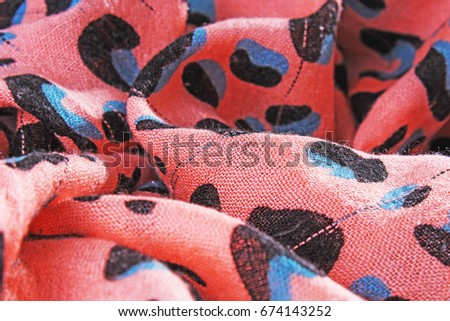 Peach animal printed fabric cloth close up photo. Scarf pattern macro texture as backdrop background. 