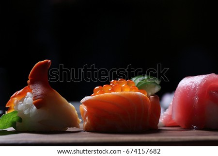 Sushi Set sashimi and sushi rolls with tea on wood background