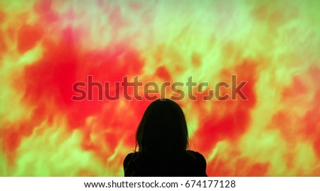 Little girl sits in front of tv watching flames. Child silhouette in front of tv.