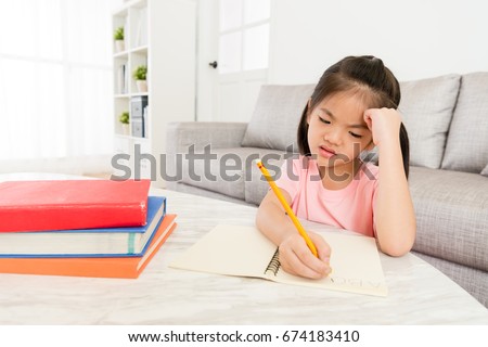 sad unhappy little female children writing english homework before back to school feeling difficulty and upset.