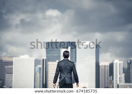Strong, determined business man in the city. Conquering fear, and adversity concept.  Royalty-Free Stock Photo #674185735