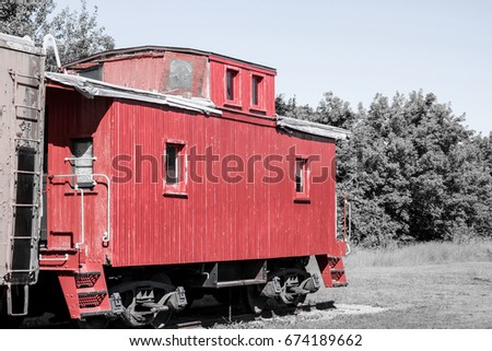 Exterior daytime color splash stock photograph of vintage red train caboose with black and white background in Orchard Park, New York in Erie County.