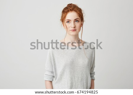 Portrait of beautiful tender ginger girl smiling posing looking at camera over white background.