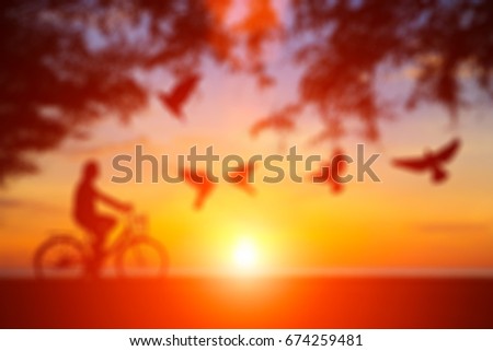 blurry Silhouette man and vintage bike relaxing in morning with water reflection 
