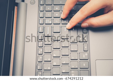 Closeup image of finger pushing button enter provide with data on the laptop computer. Press keyboard on the notebook hardware equipment concept. Above view with copy space