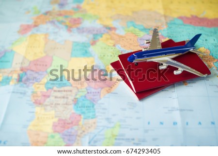 toy aircraft with two neutral passports on the map, travel concept, flight to africa, trip by plane. red pasport and plane on world map Royalty-Free Stock Photo #674293405