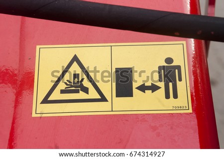 Warning sign on agricultural machinery. Do not put your hands out. Injury to hands is possible. Be attentive. Observe the distance.
