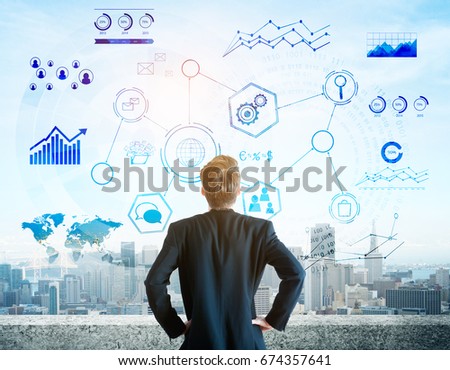 Back view of thoughtful young businessman standing on concrete rooftop and looking at city with abstract digital business projection. Futuristic touchscreen concept. Double exposure 