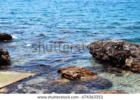 Sunny day on rocky sea coast and clean blue water. Montenegro