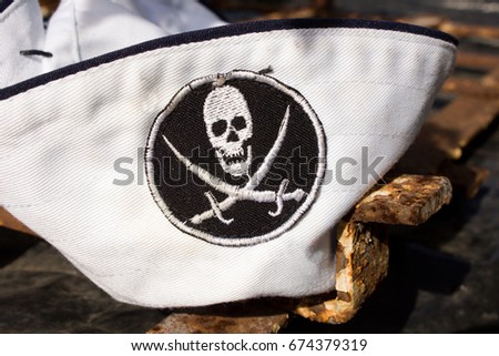 Pirate Emblem. Jolly Roger. Pirat flag close-up. Bones and skull. Pirate symbol. Young pirate. The designation of a pirate by a sailor on a cap. symbol of pirates