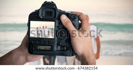 Composite image of cropped image of hands holding camera 
