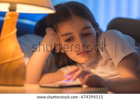 The cute girl phone in the bed. night time
