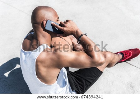 side view of african american man talking on smartphone on court